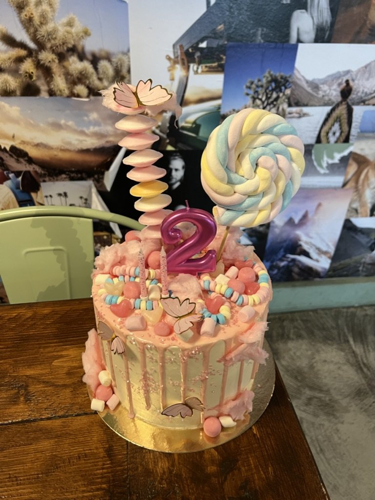 Rosa Drip-Torte mit Lollis und Marshmallows im Café