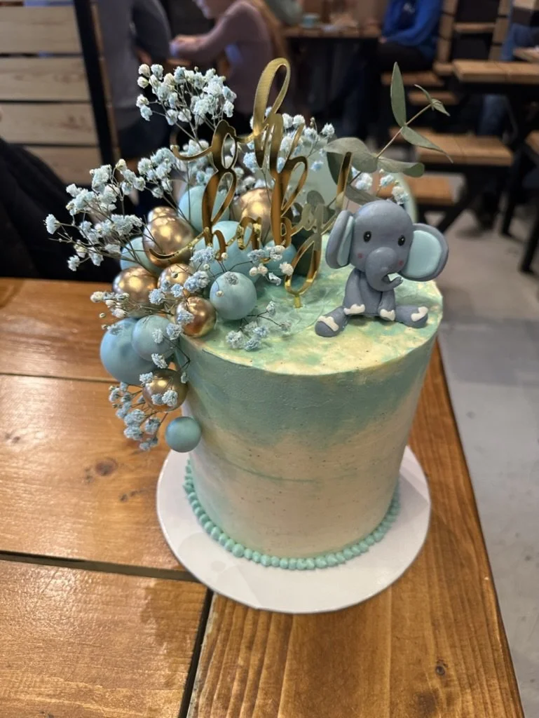 Mintgrüne Torte mit Elefanten-Figur und Trockenblumen