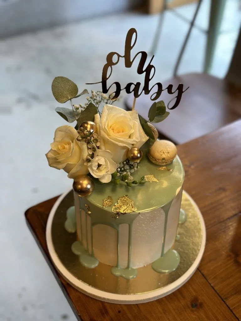 Torte mit hellgrünem Drip, gelben Rosen und Oh-Baby-Topper