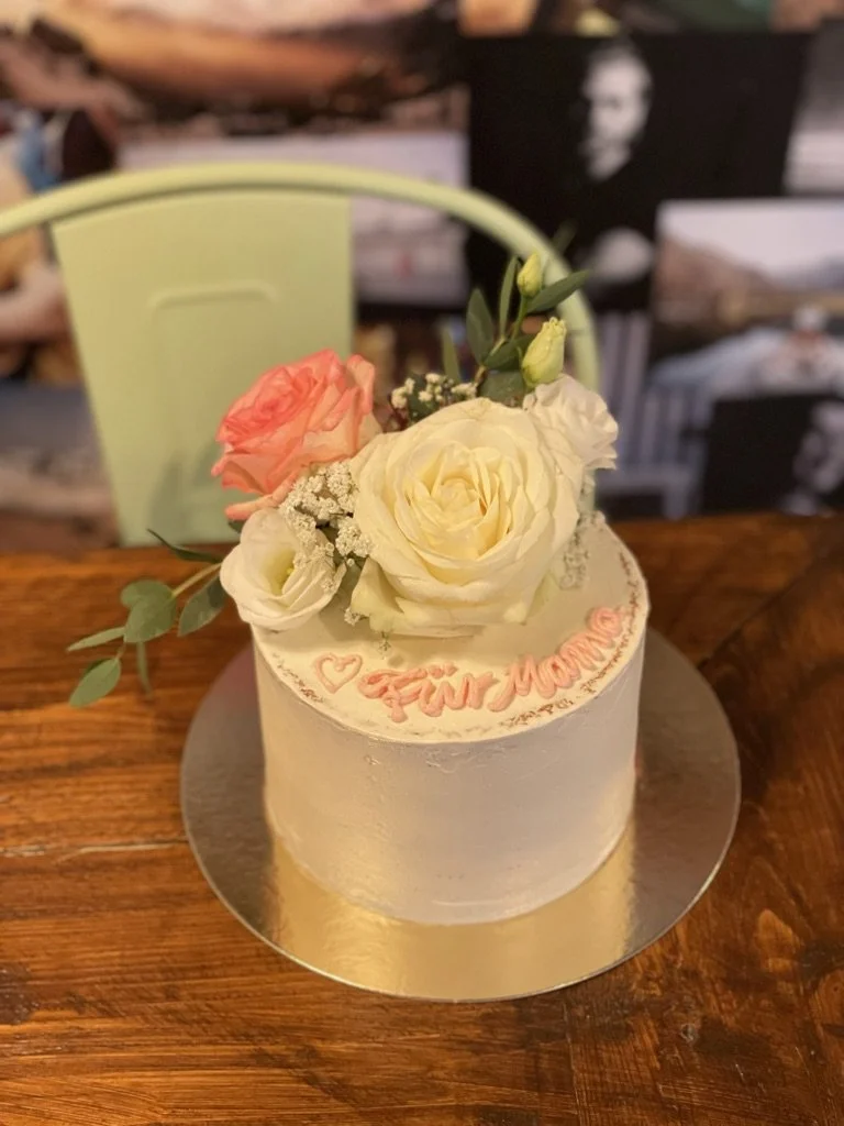Weiße Torte mit cremefarbenen Rosen und Schriftzug