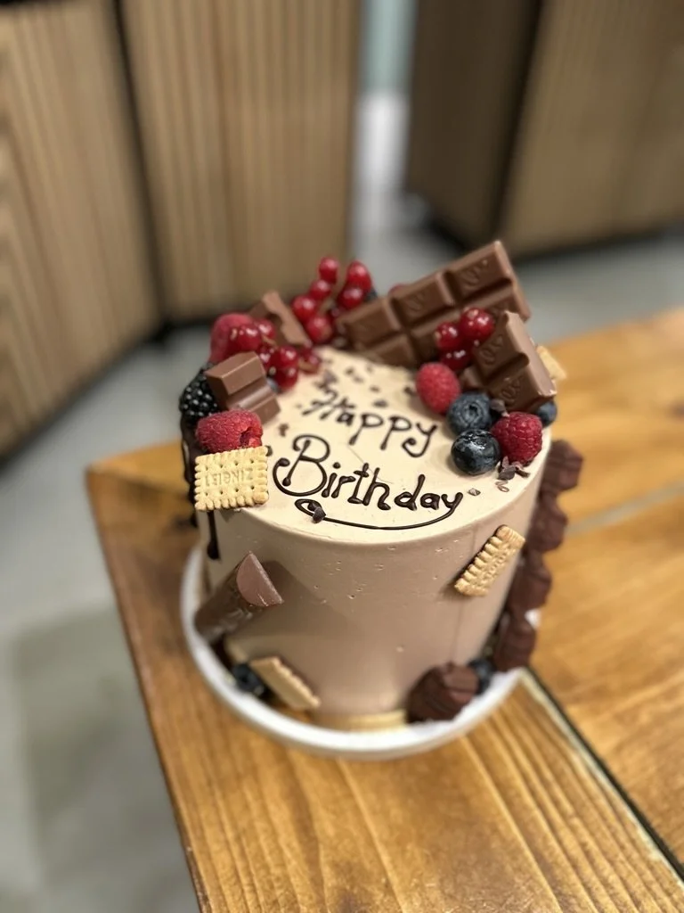 Torte mit Schokolade, Beeren und Happy-Birthday-Schriftzug