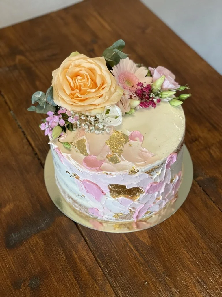 Torte mit rosa Farbakzenten und frischen Blumen