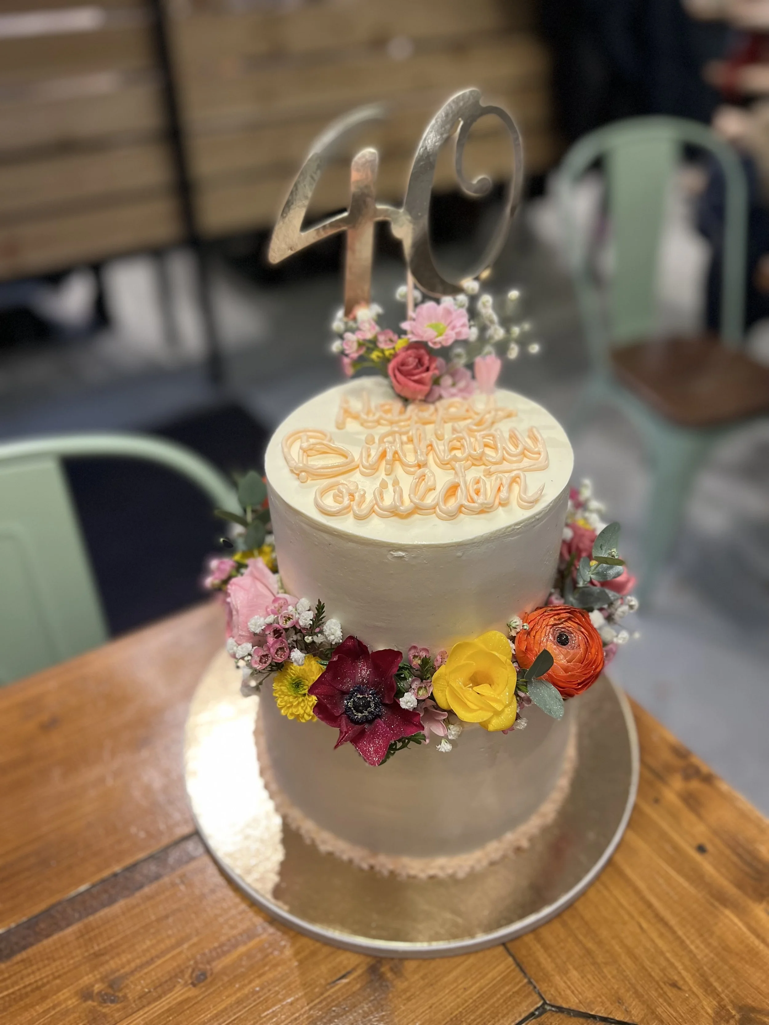 Zweistöckige Torte in Beige mit bunten Blumen und goldener Zahl 40