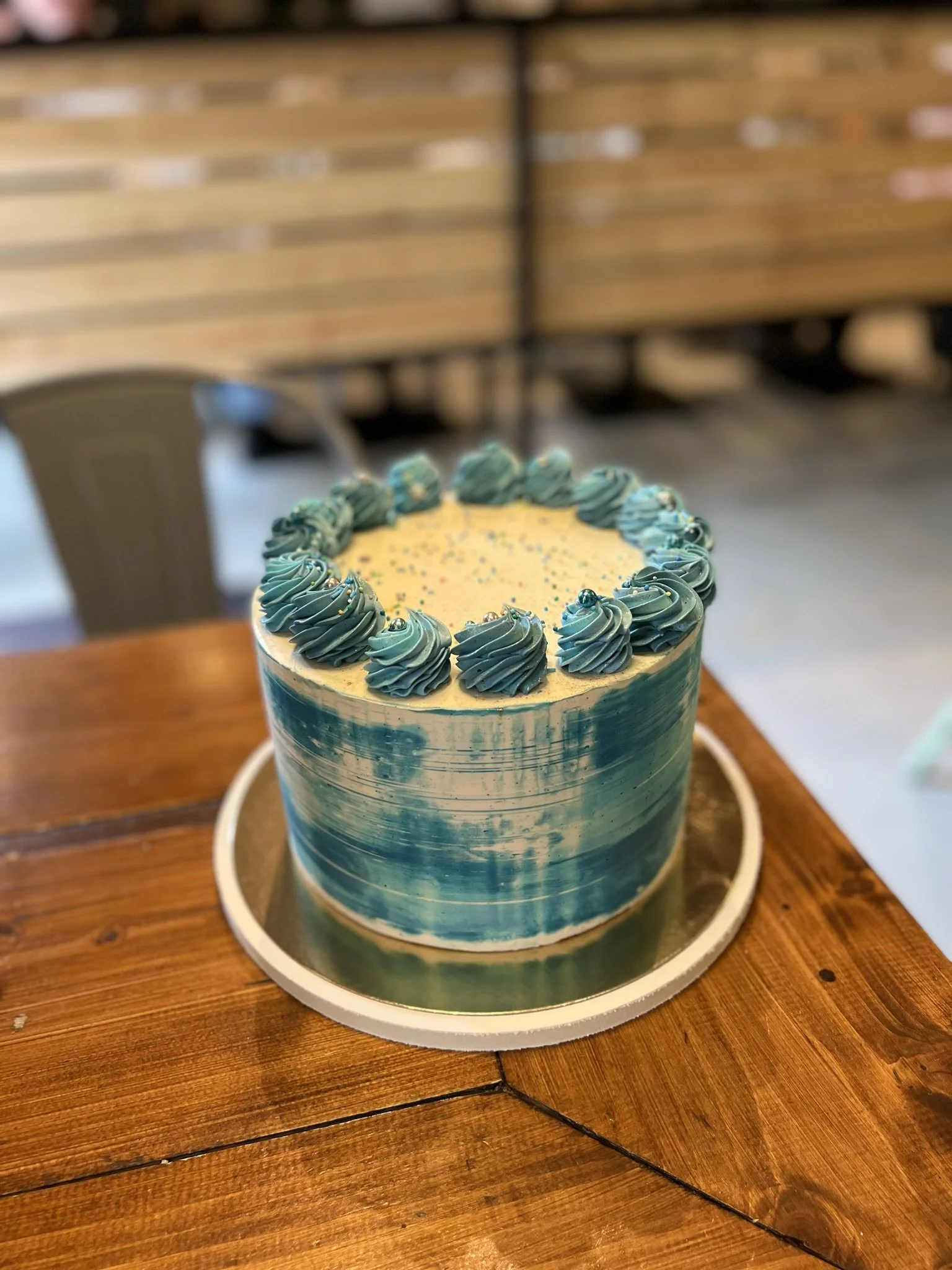 Torte mit blauen Pinselstrichen und Sahnetupfen