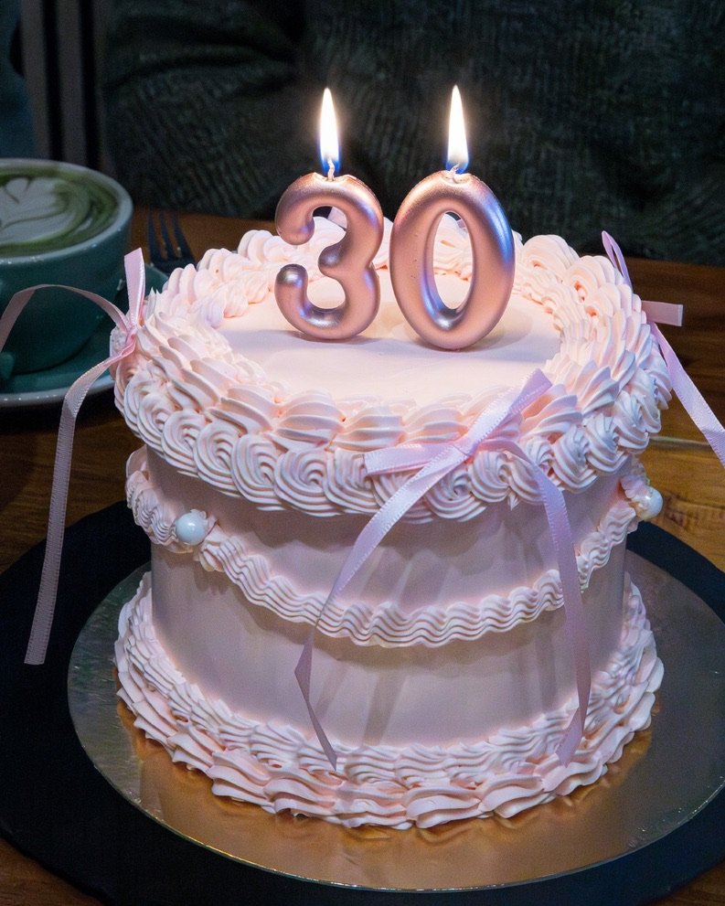 Fliederfarbene Vintage-Piping-Torte mit Schleifenbändern und Zahlenkerzen