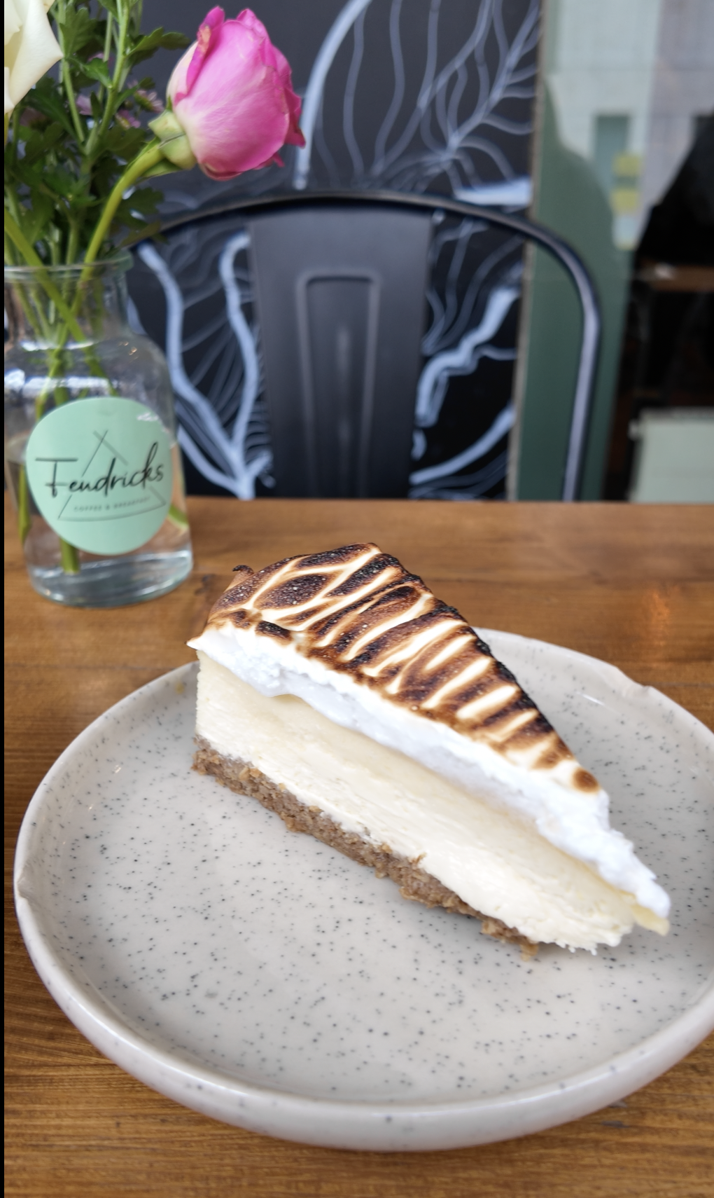 Ein Stück NY Cheesecake Lemon Baiser mit abgeflämmtem Baiser auf einem Teller