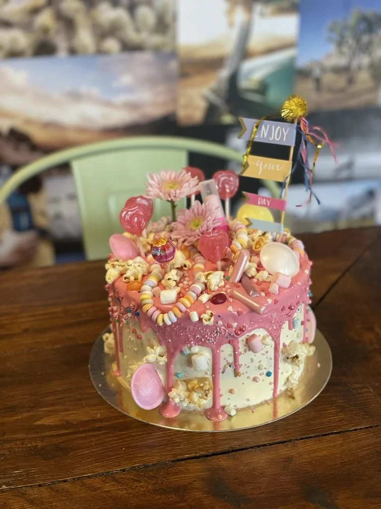 Rosa Drip-Torte mit Süßigkeiten und Lollis