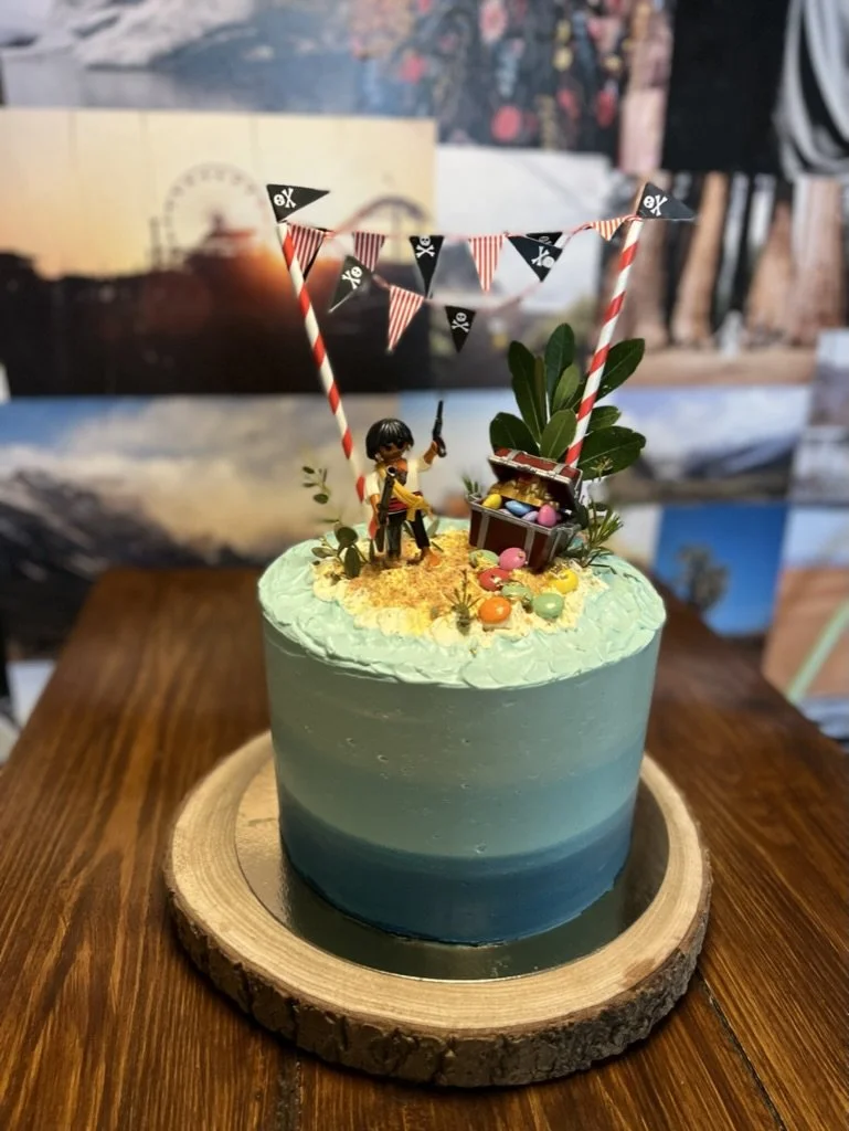 Blau-grüne Torte mit Wimpelkette und Figuren