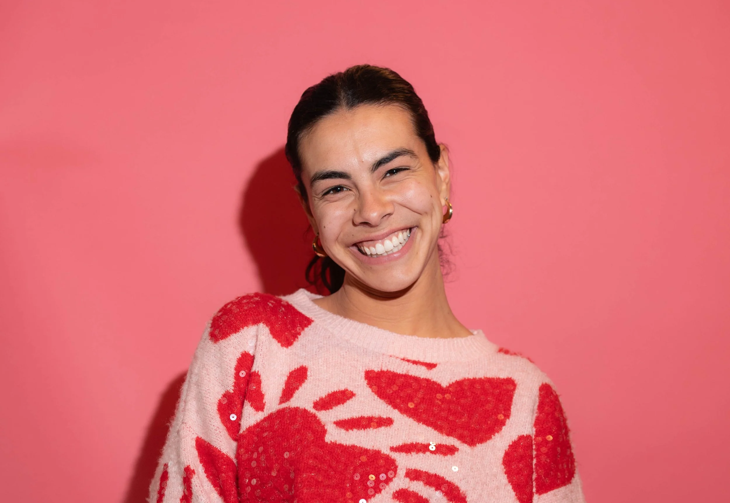 Professional corporate headshot posed on a pink backdrop