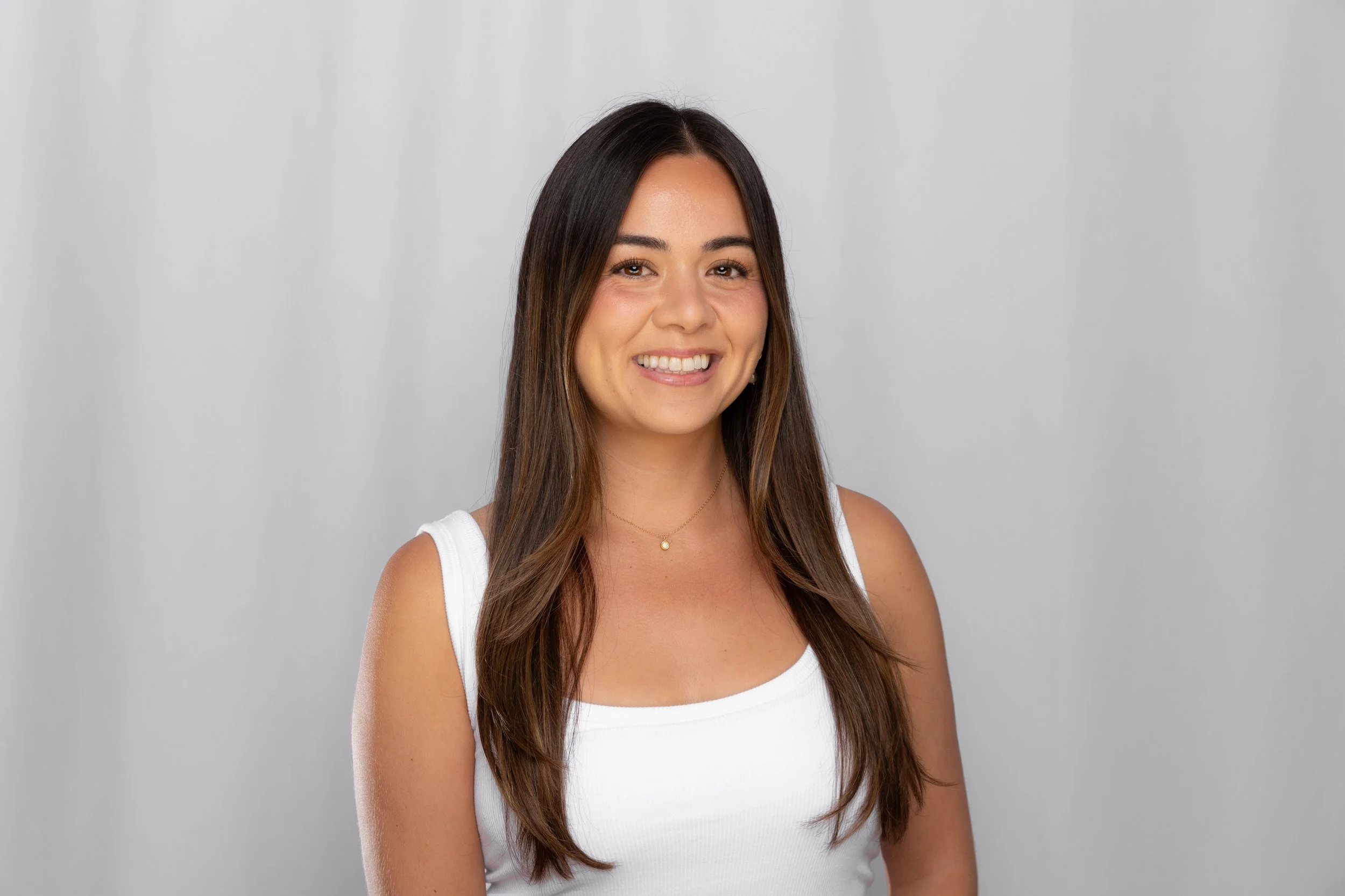 Professional corporate headshot posed on a pink backdrop