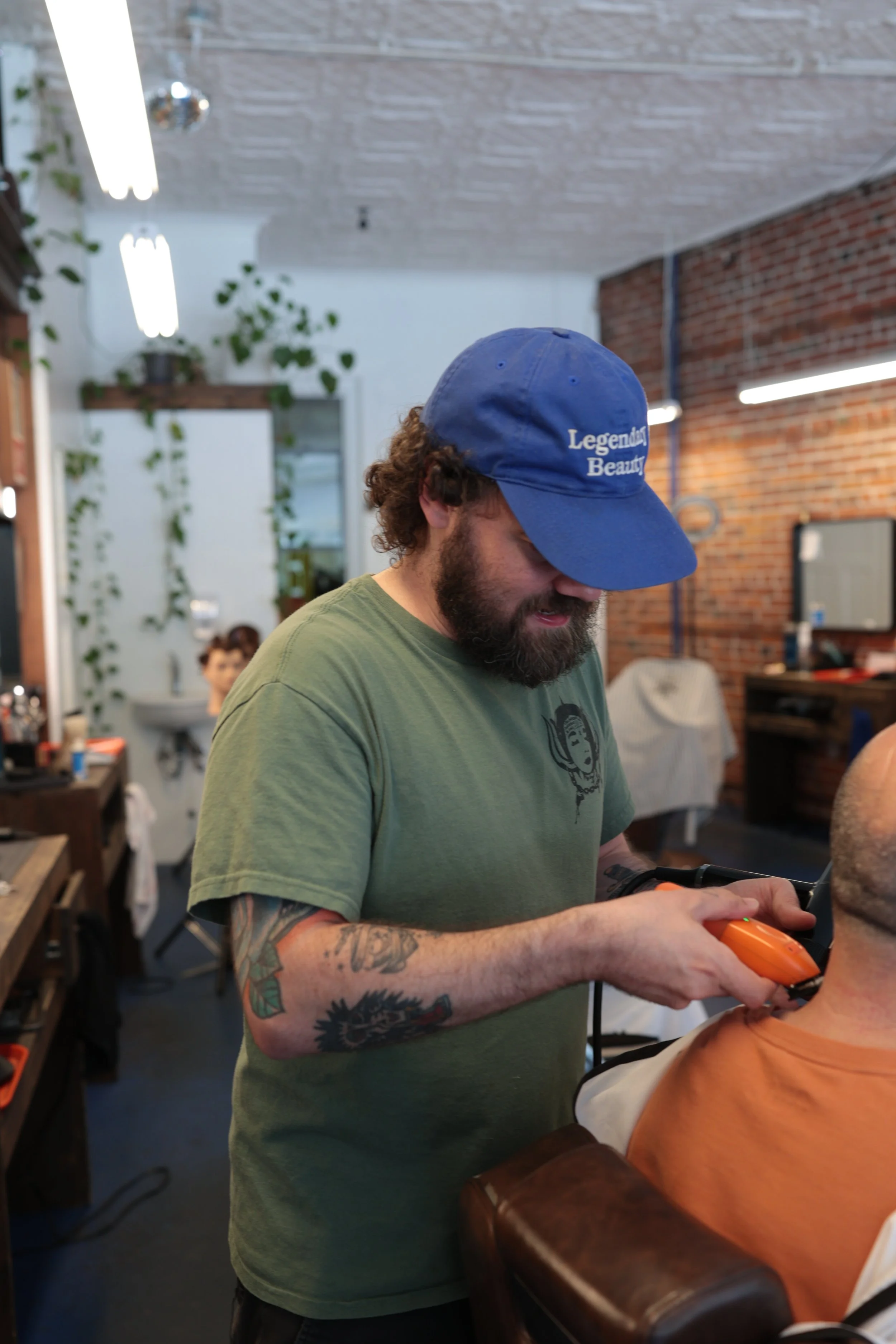 a barber doing a haircut at rebellion barbershop
