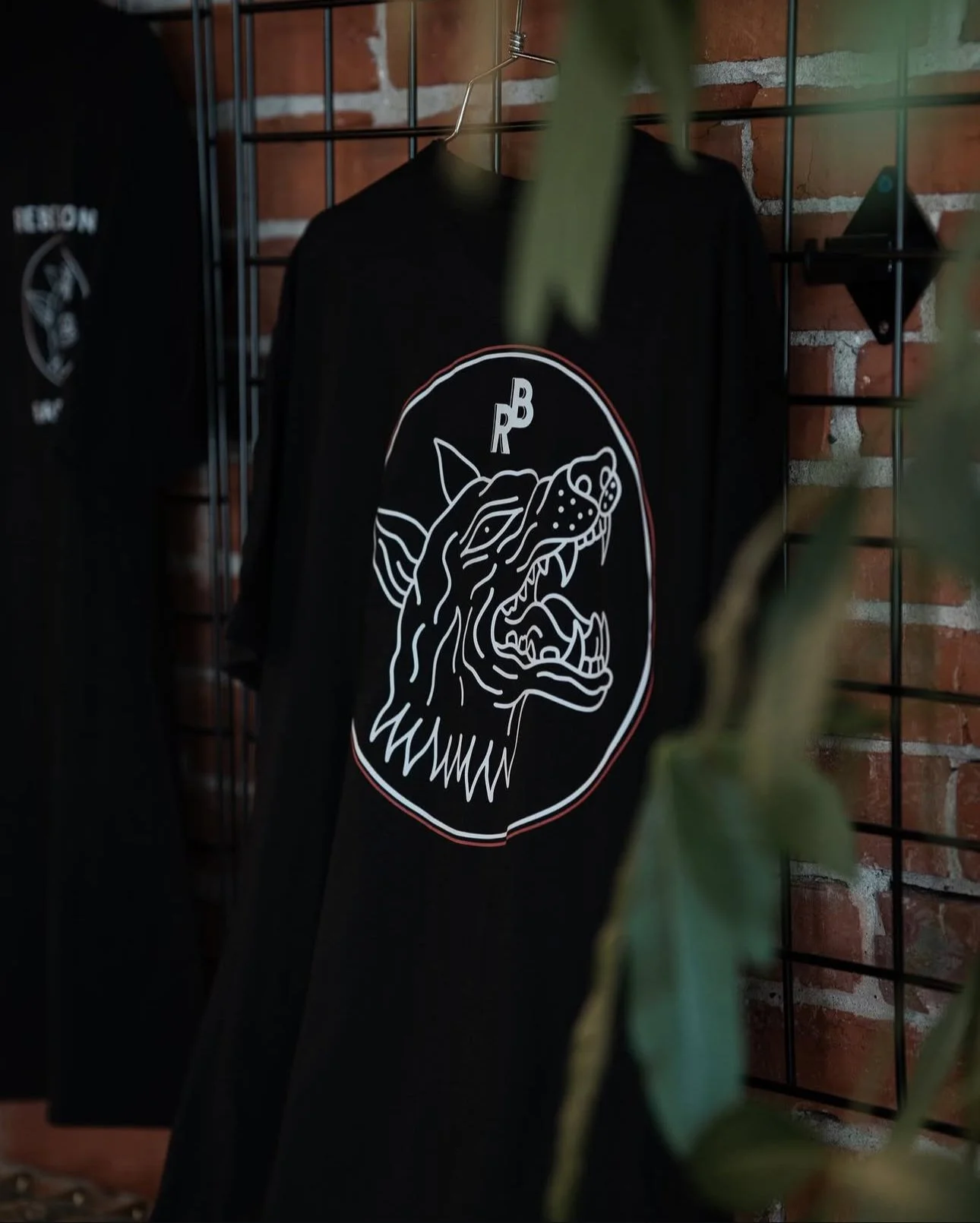 Rebellion Barbershop merch display with wolf logo T-shirt hanging on rack in Victoria BC.