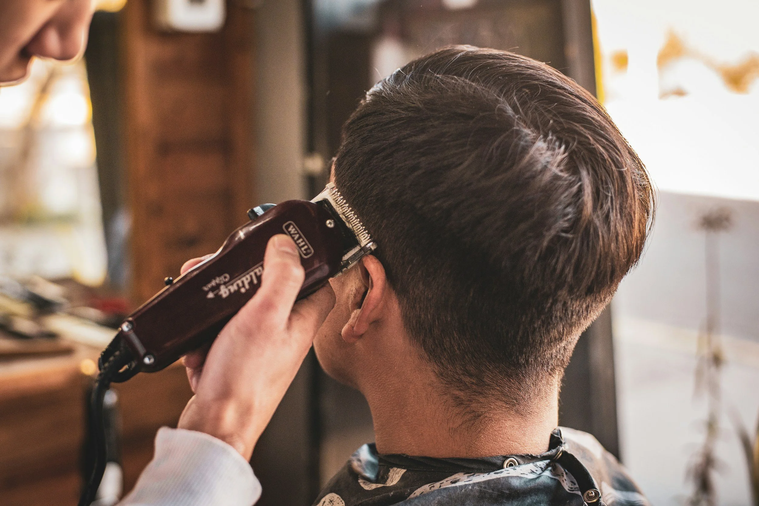 Barber performing a clean buzzcut with clippers at Rebellion Barbershop in Victoria BC – even-length cut, precise finish.