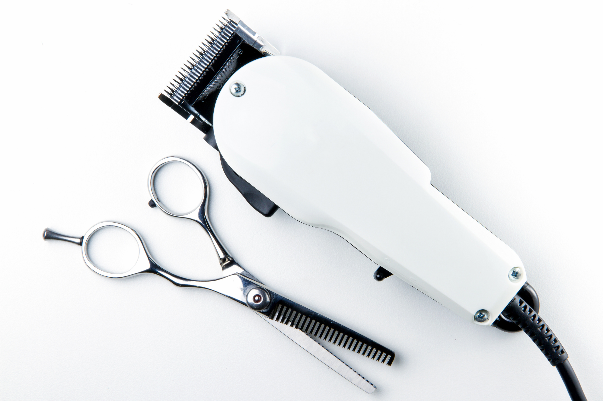 Professional barber clippers and scissors on white background — Rebellion Barbershop Victoria.