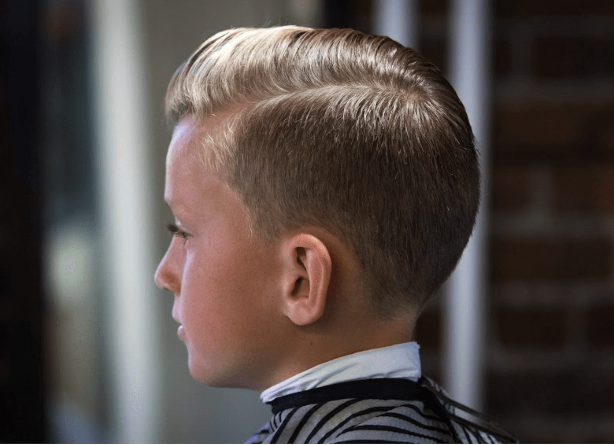 Young boy with a clean side-part haircut at Rebellion Barbershop, kid-friendly barbershop service in Victoria BC.