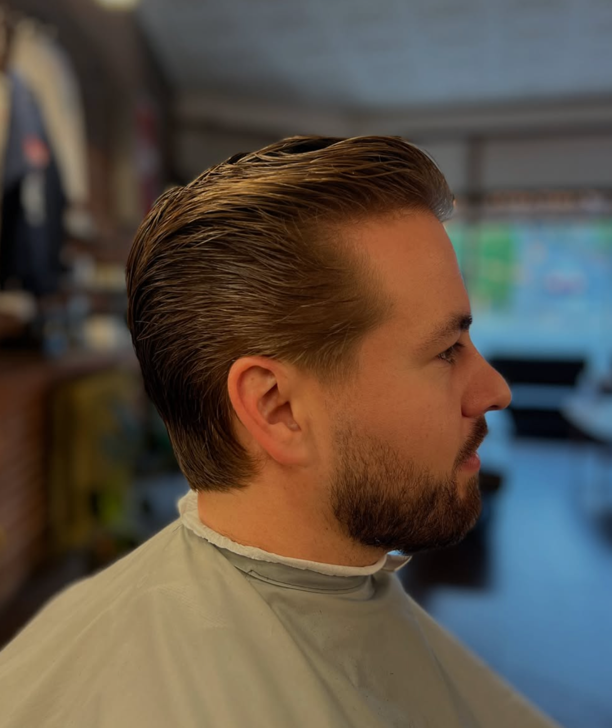 Slick back men’s haircut with a clean neckline at Rebellion Barbershop Victoria