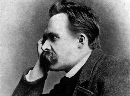 A black and white portrait of a man with a mustache and goatee, resting his head on his hand, wearing a coat.