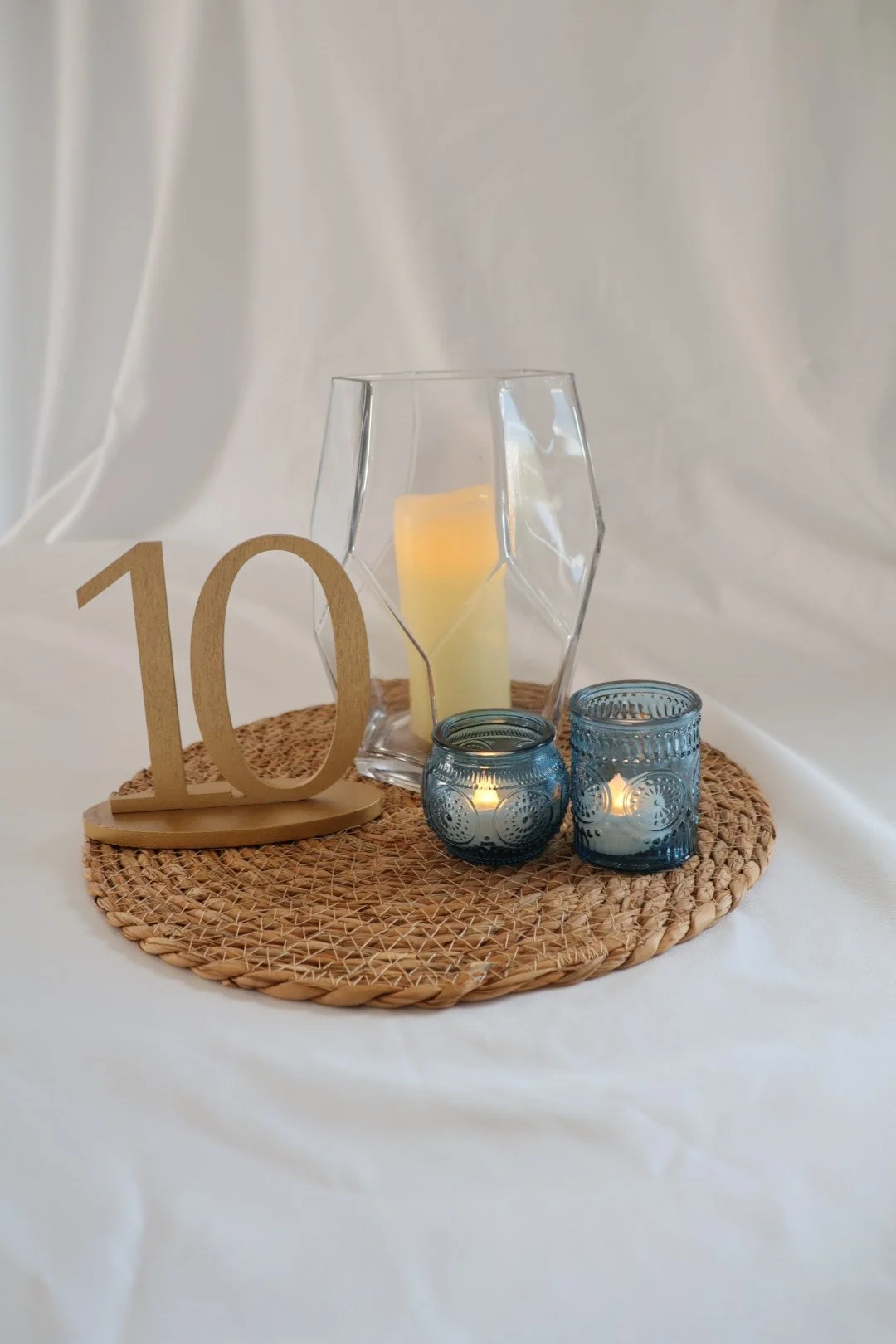 Blue votives (70) Wicker charger (150) Gold table numbers (15) Geometric vase (4)
