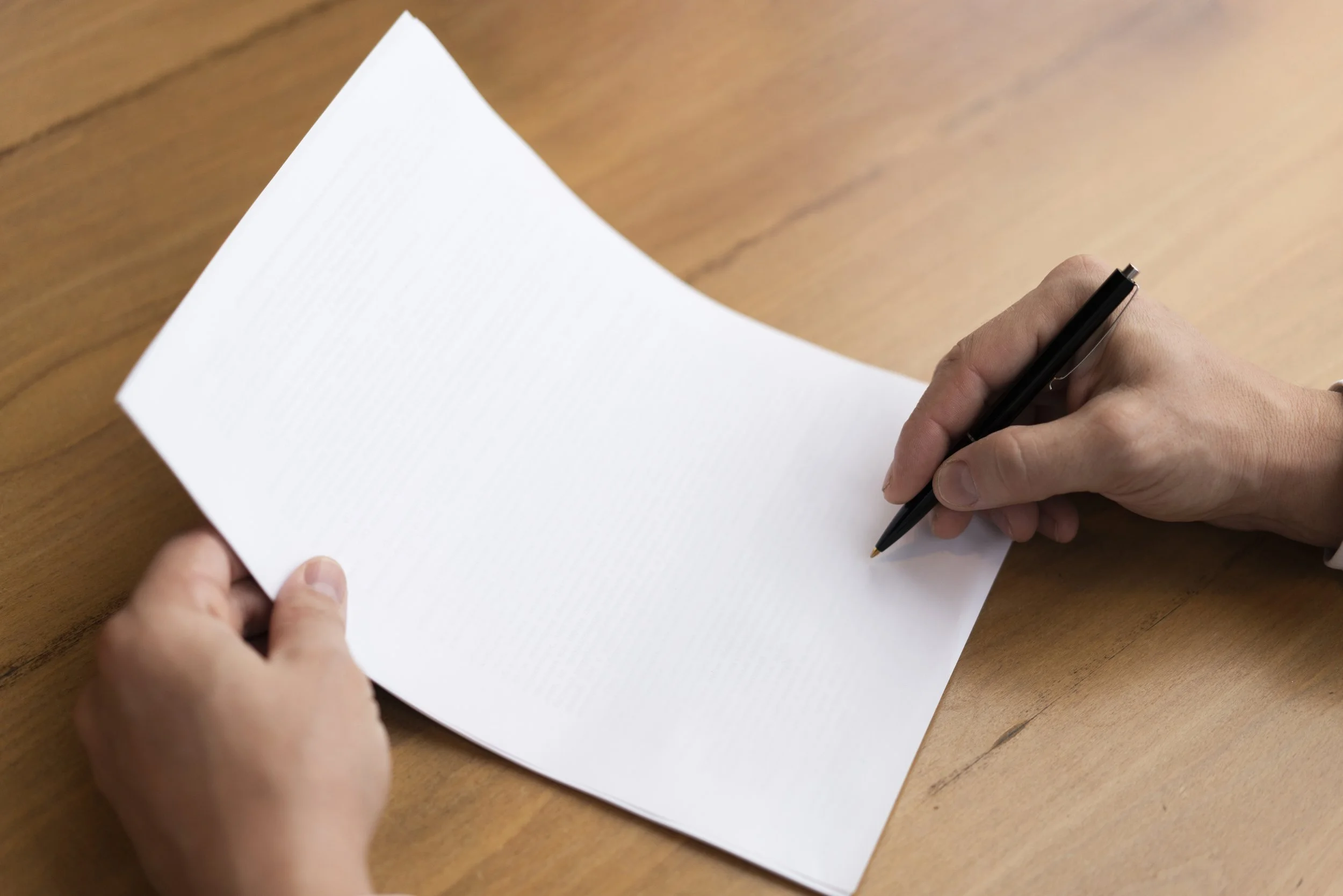 Close up of hands signing counseling intake paperwork to get ready for a therapy consult