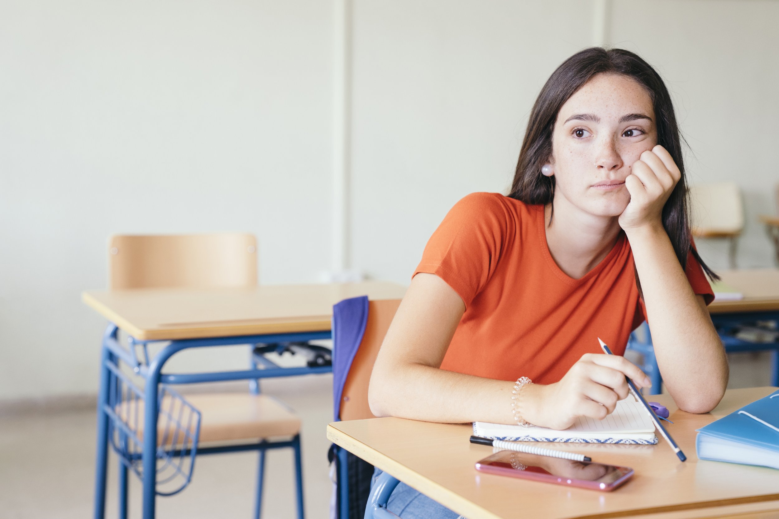 Person sitting with unfinished tasks while feeling emotionally drained.