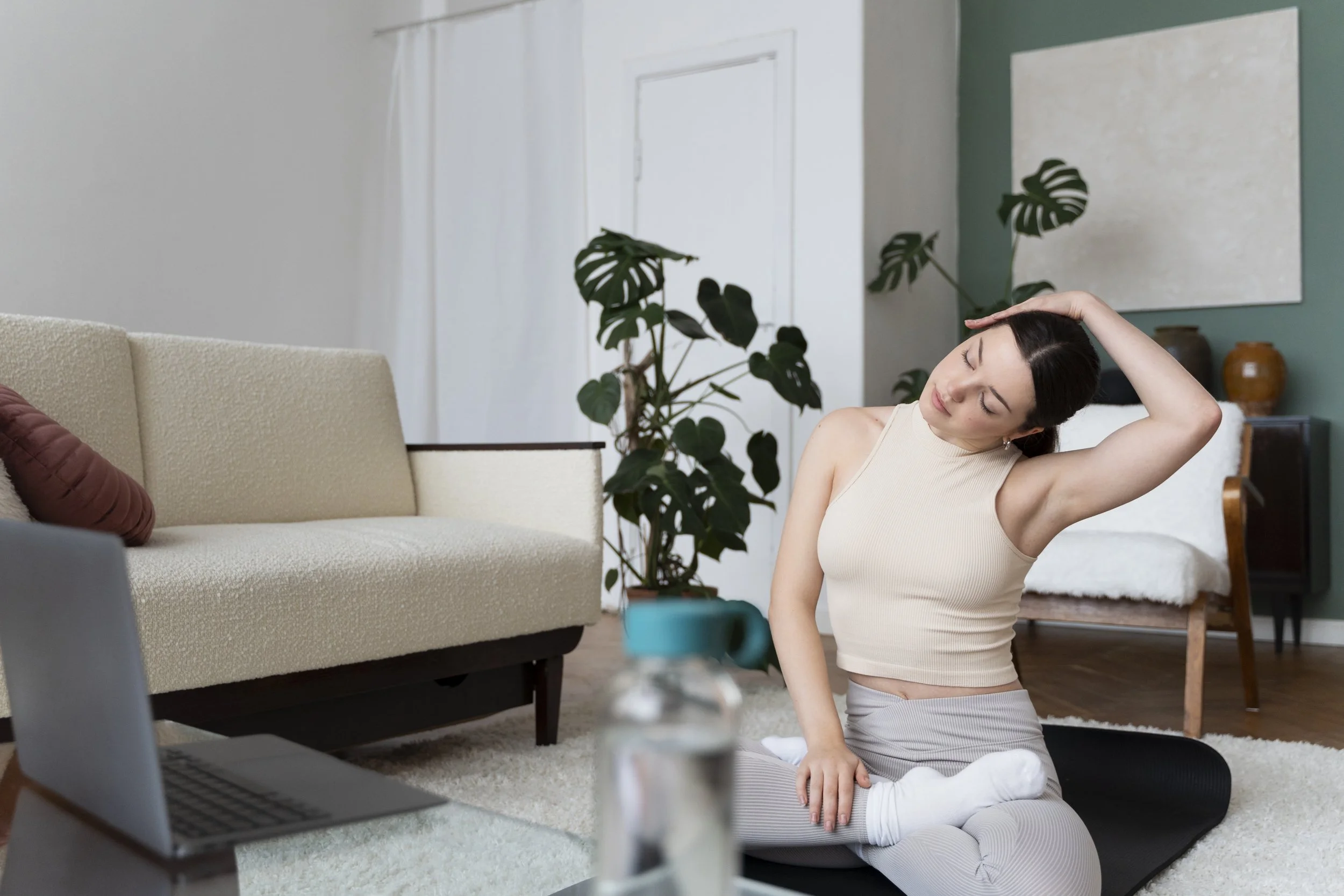 Client stretching and grounding on a yoga mat before a counseling consult call at home