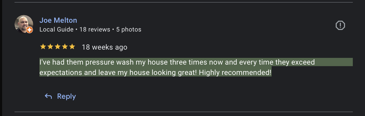 Close-up of a smiling woman with black hair in a greenhouse surrounded by green plants.
