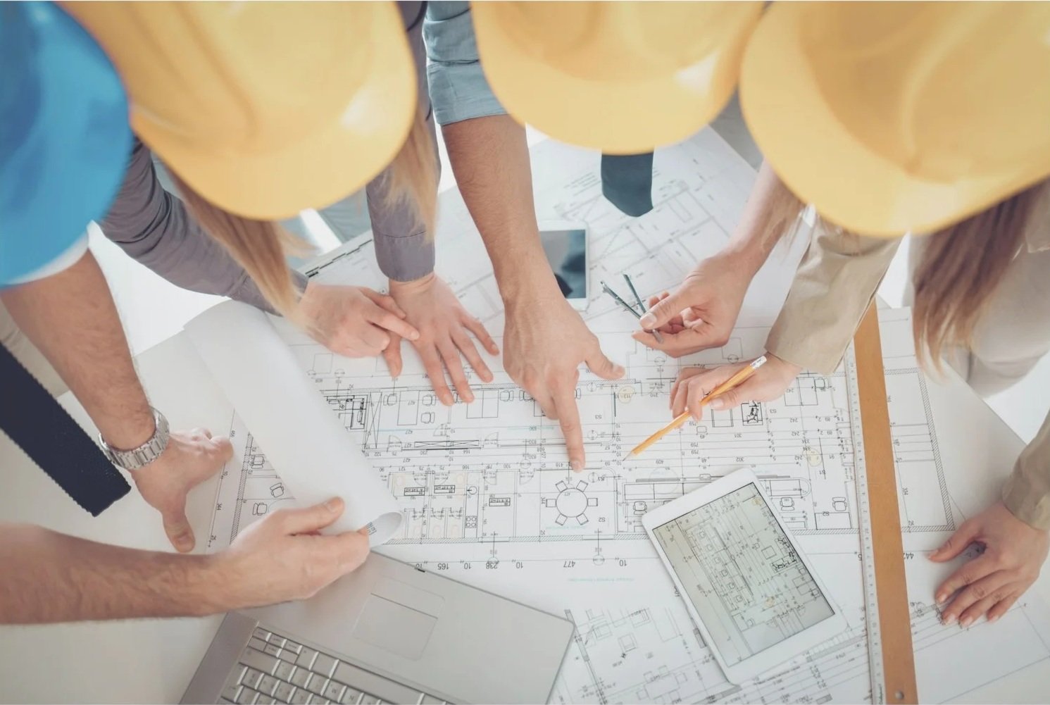 Team collaborating over engineering drawings and project plans.