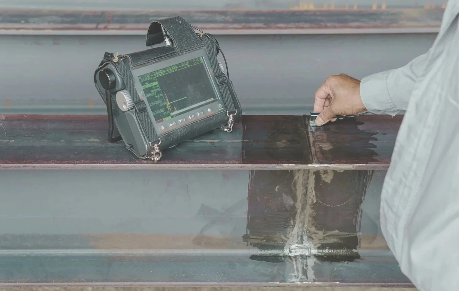 Technician performing non-destructive testing on industrial equipment, representing NDE coordination and compliance oversight.