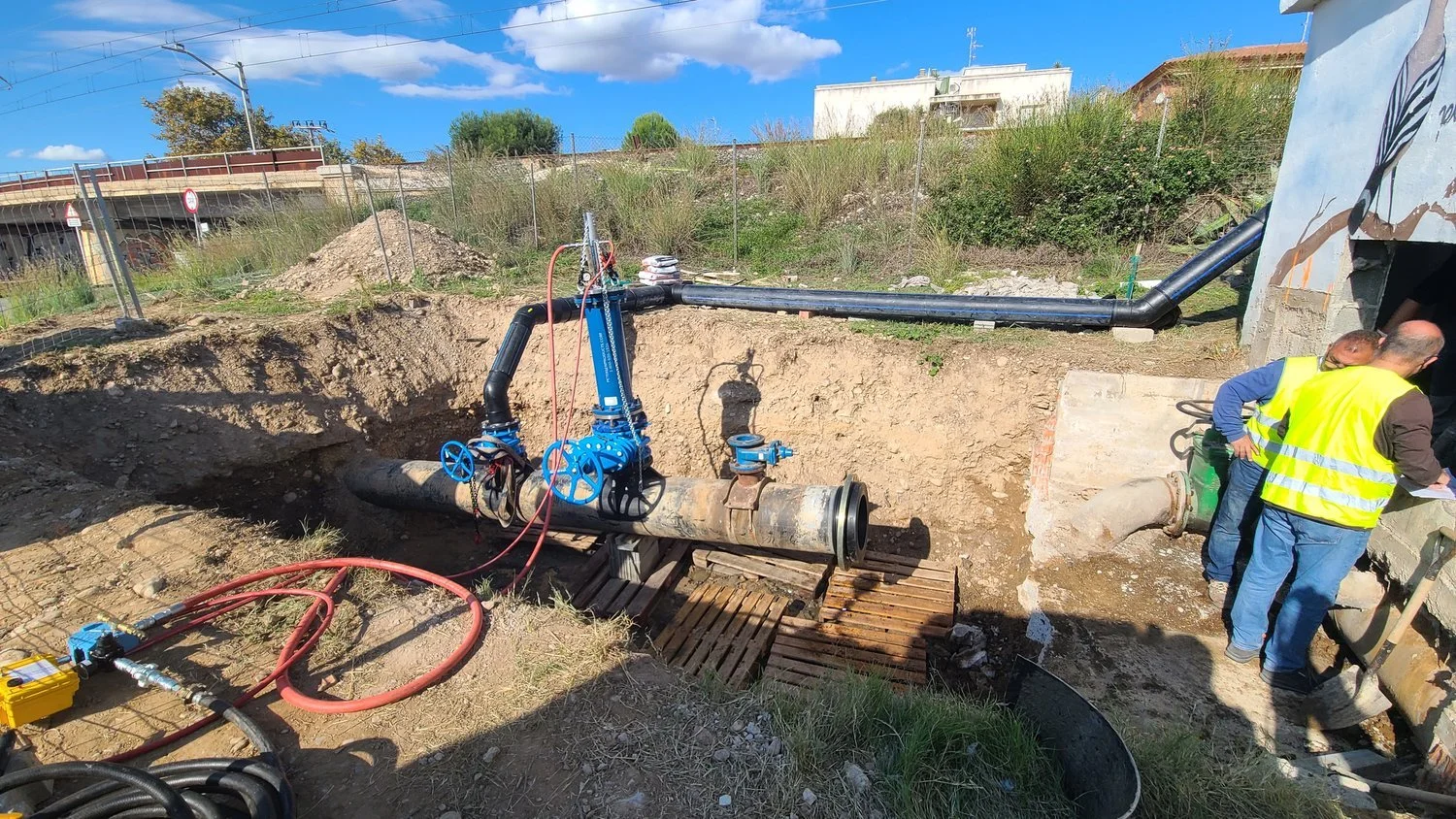 Crew performing municipal sewer line intervention in Tarragona, Spain, with trench excavation, pipe alignment, and valve installation for system rehabilitation.