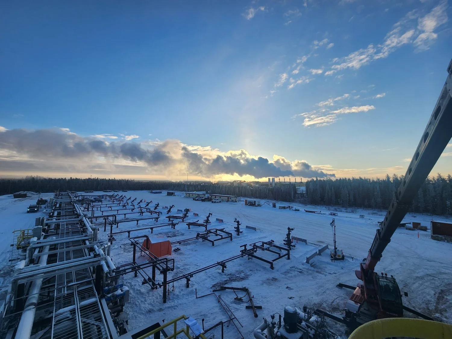 Wide view of oil and gas piping infrastructure and valve skids at a winter facility, demonstrating construction, inspection, and quality control requirements.