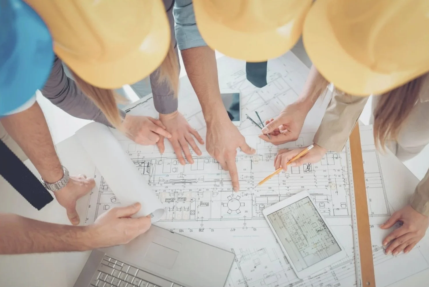 Project team reviewing engineering drawings and schedules, representing shutdown and turnaround planning services.