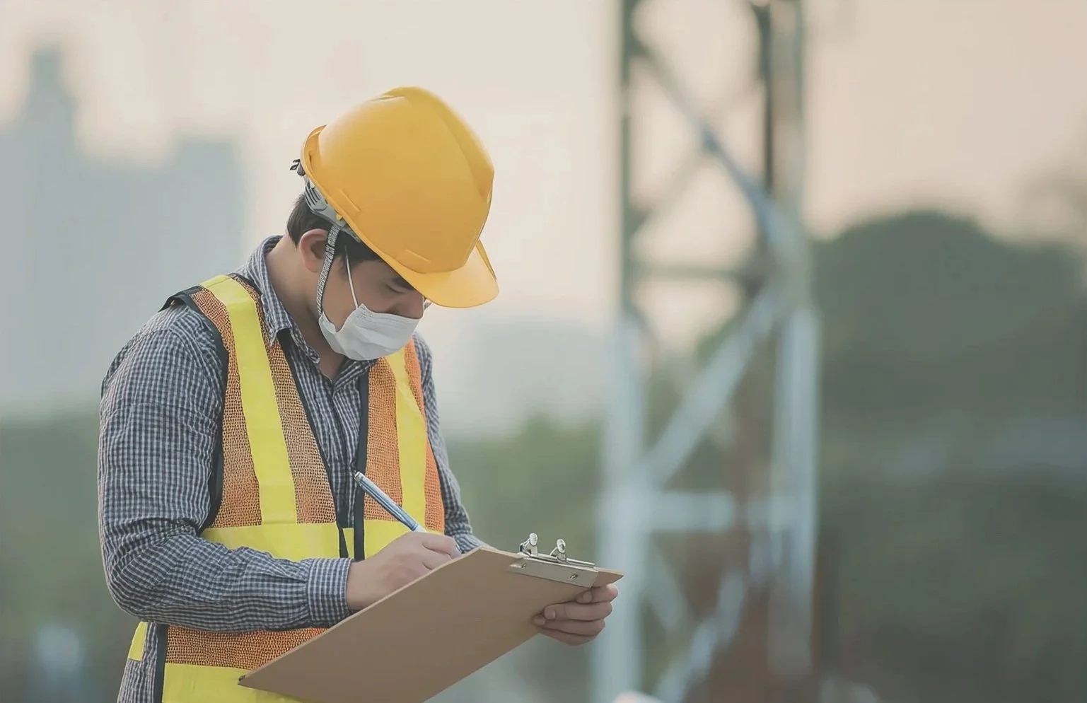 Industrial inspector in safety gear performing field inspection with clipboard.