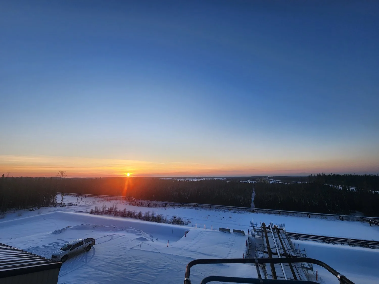 Wide landscape view of an industrial site at sunrise in a winter setting, representing Steelhead’s field-based experience, reliability, and commitment to quality outcomes.