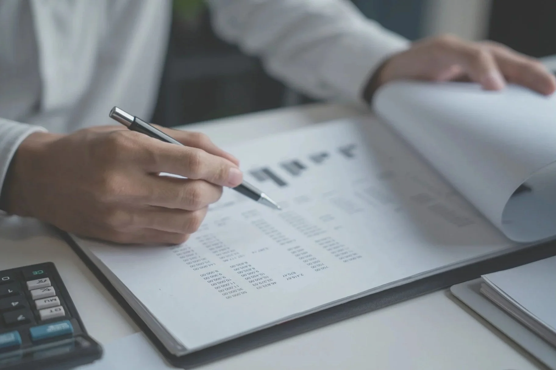 Consultant analyzing quality reports and audit charts on paper.