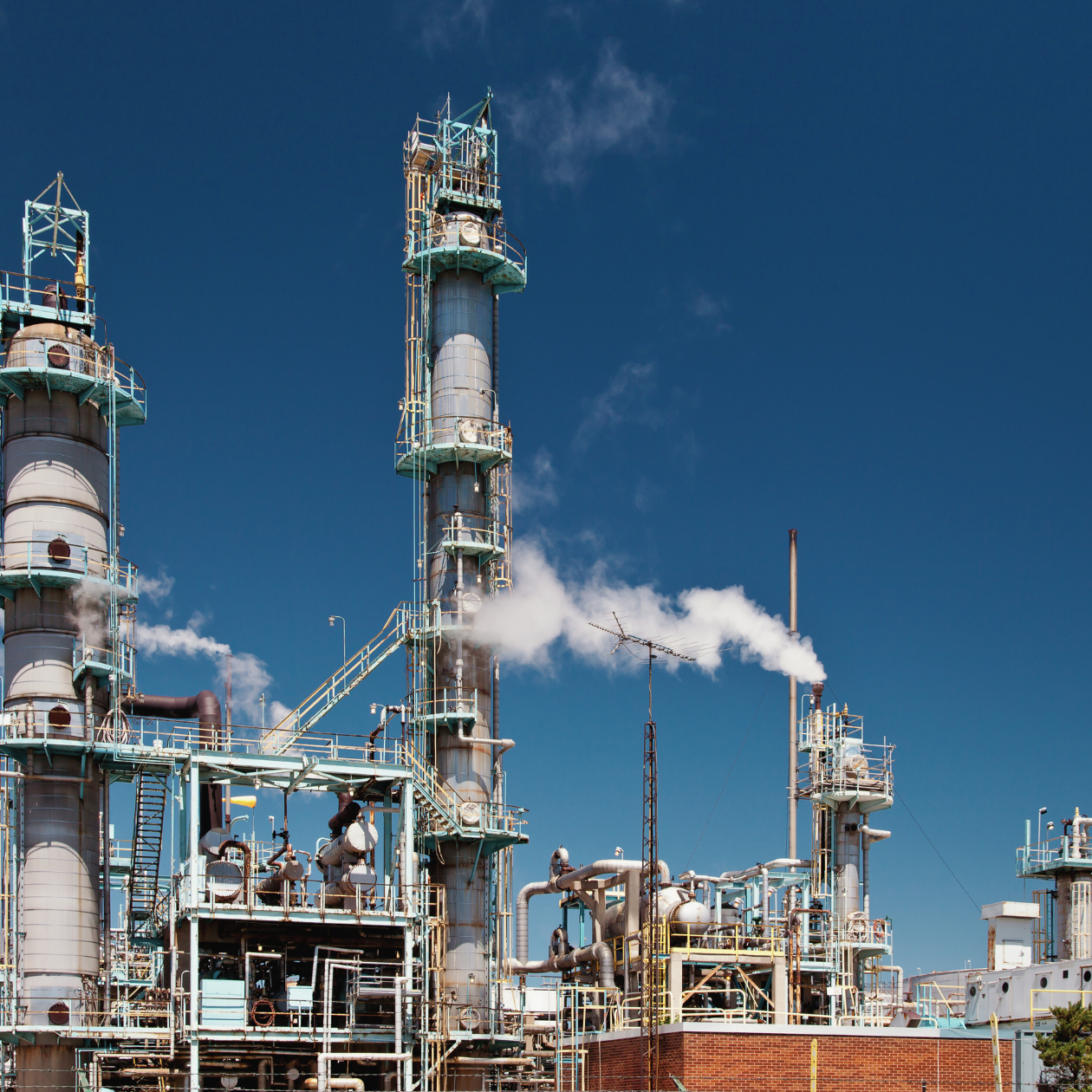 Refining, petrochemical, and chemical processing facility with industrial towers and piping supporting regulated quality and safety programs.