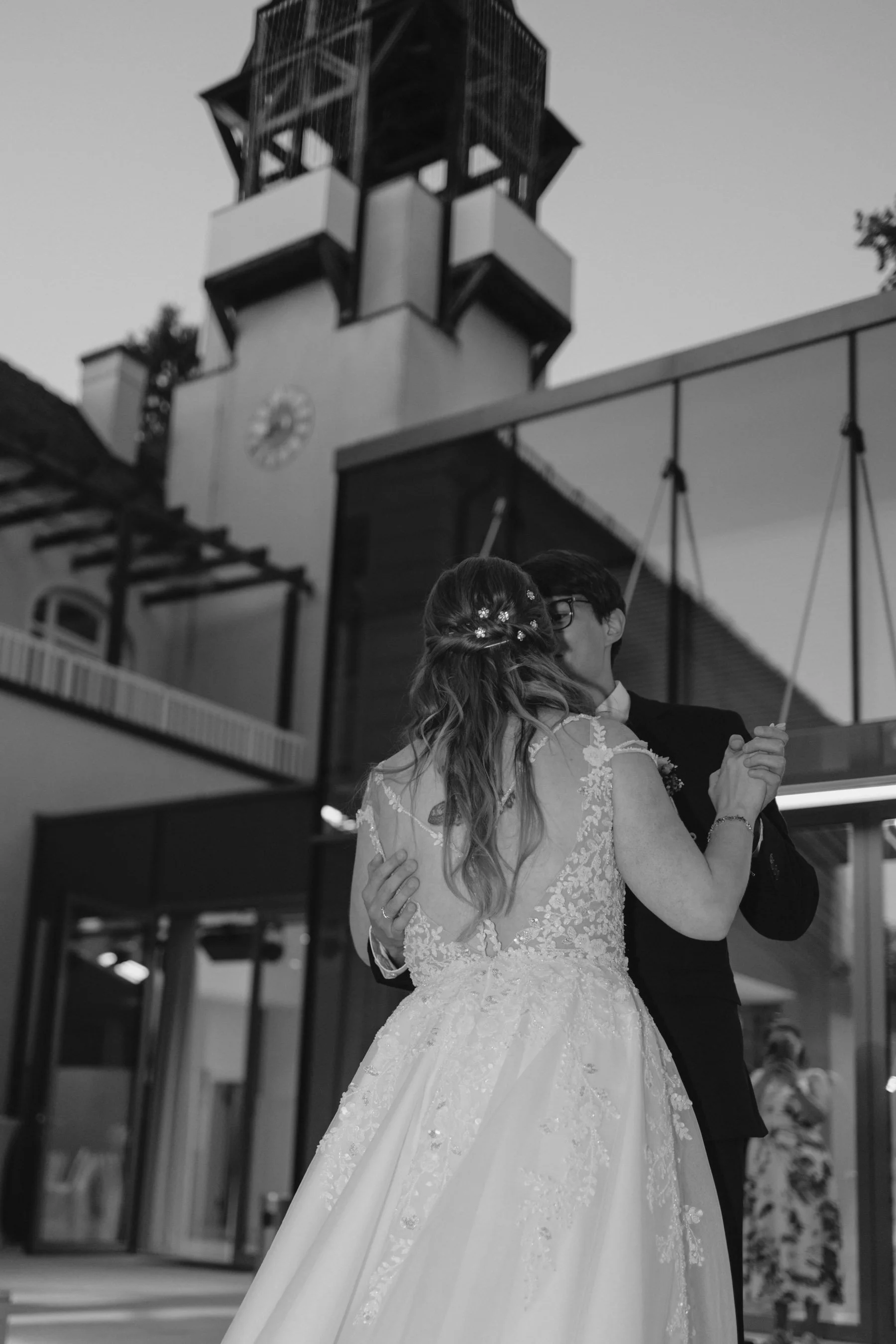 Braut und Bräutigam tanzen bei ihrer Hochzeit im Freien, im Hintergrund ist der Uhrturm sichtbar.
