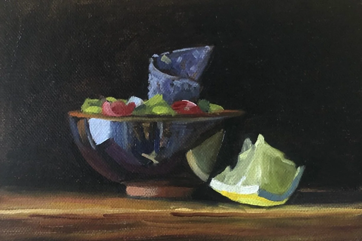 Still life painting of a glass bowl with grapes and strawberries, a partially squeezed lemon wedge beside it, set on a dark background.