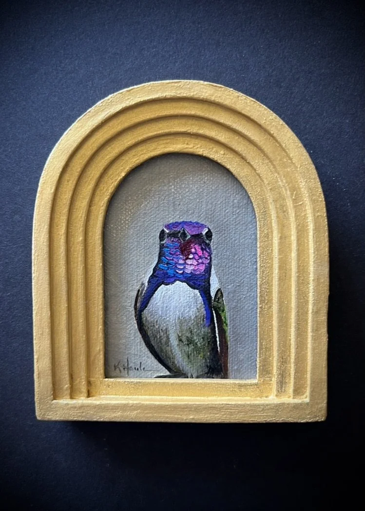 Miniature painting of a hummingbird framed in a gold arched frame.