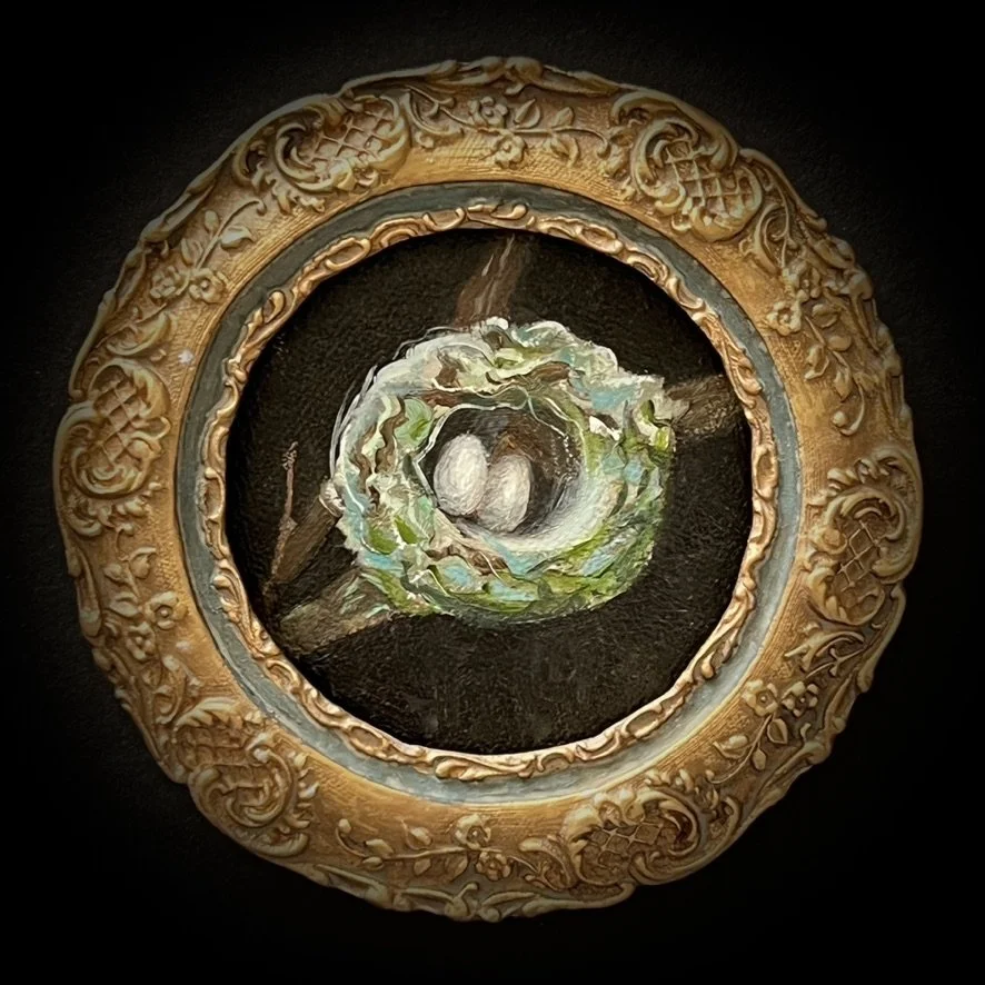 Painting of a bird's nest with eggs inside, viewed through an ornate gold and black circular frame.