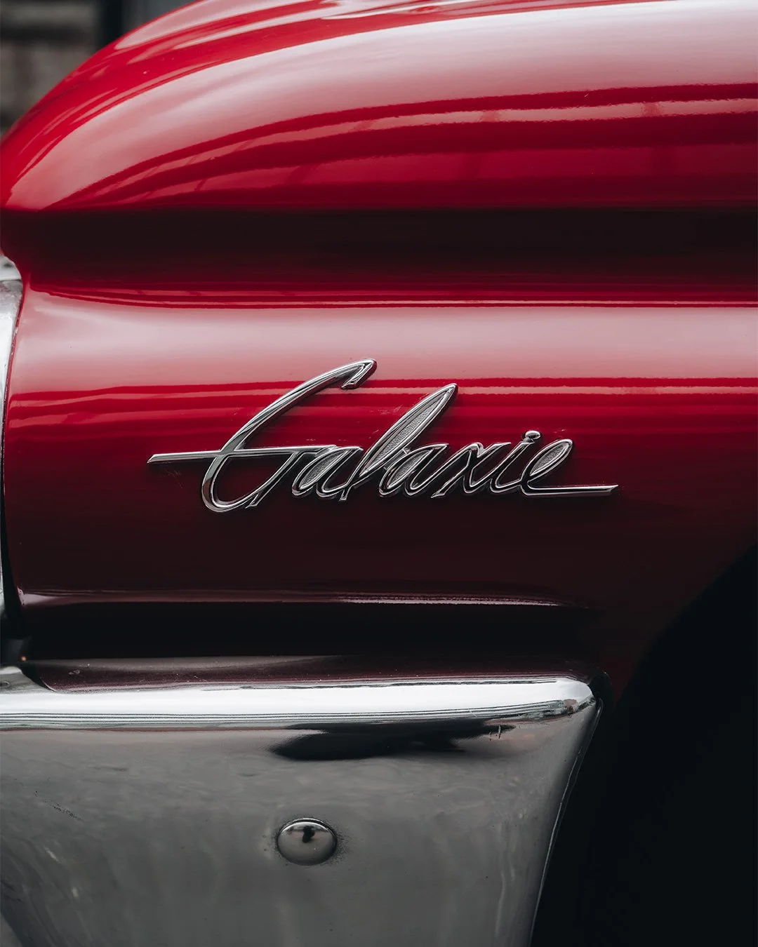 Fotografía automotriz clásica, emblema Ford Galaxie en carrocería roja vintage