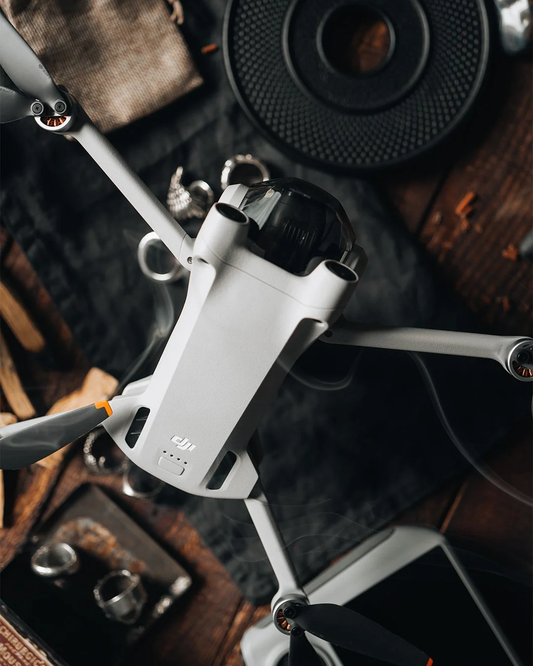 Fotografía de producto DJI Mini, drone sobre superficie oscura con accesorios
