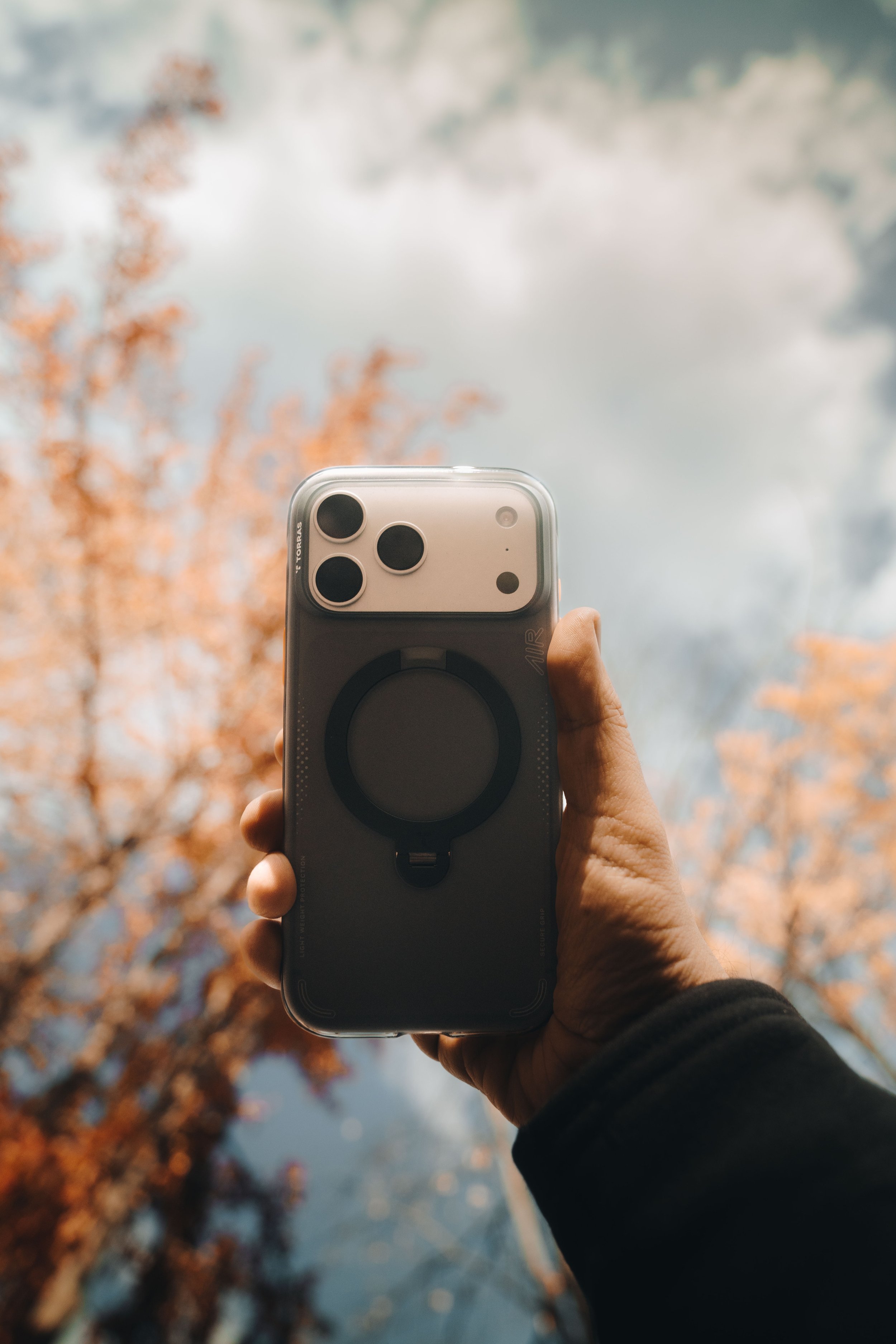 Fotografía comercial Torras, funda MagSafe para iPhone con fondo de cielo otoñal
