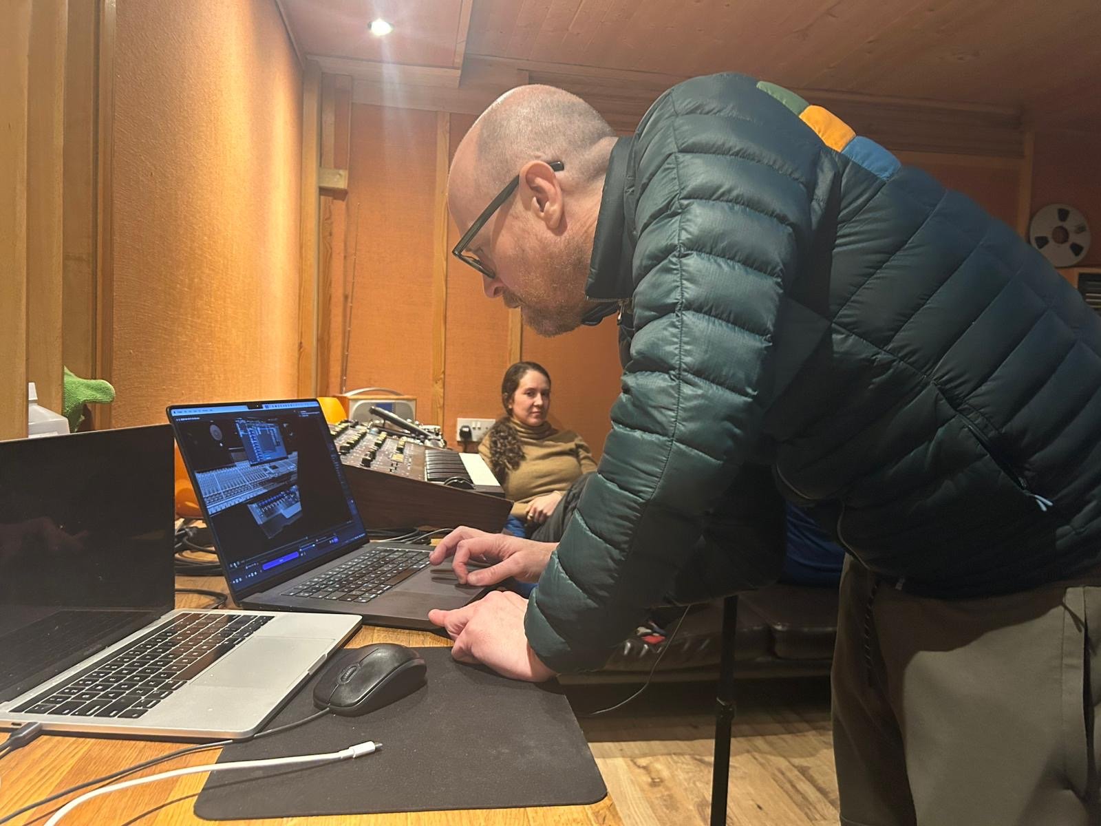 A smiling man with his friend chatting about music