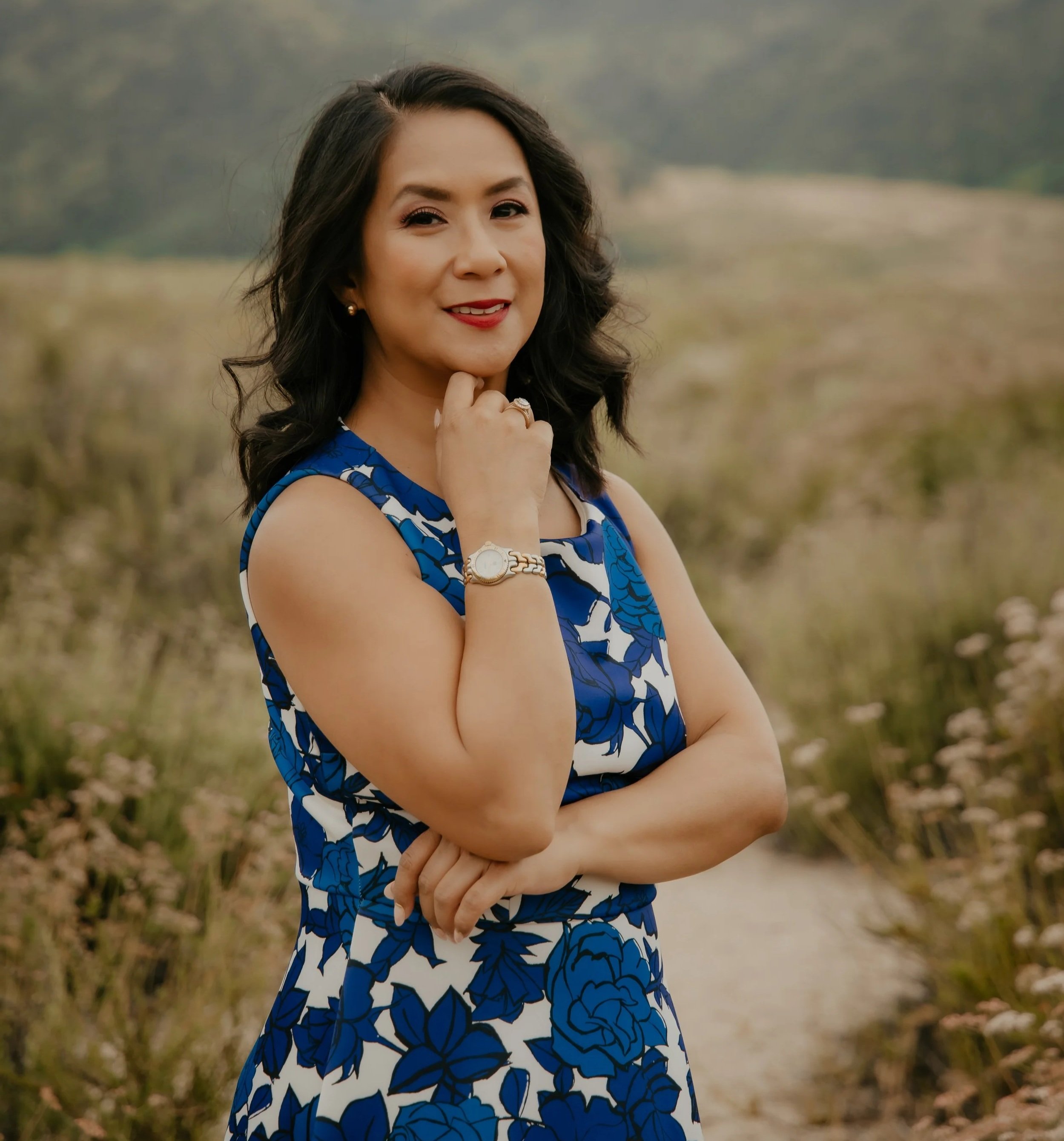 Karen in a blue flowered dress in a field.