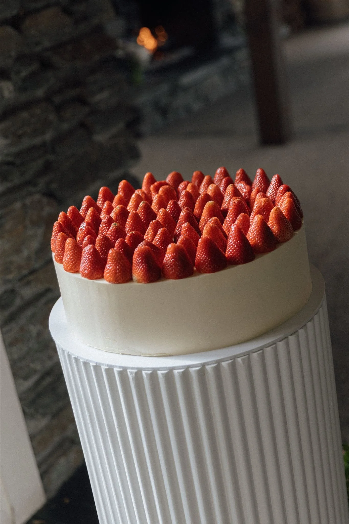 Black and white close-up of an engagement ring with a diamond and a wedding band on a curved surface.