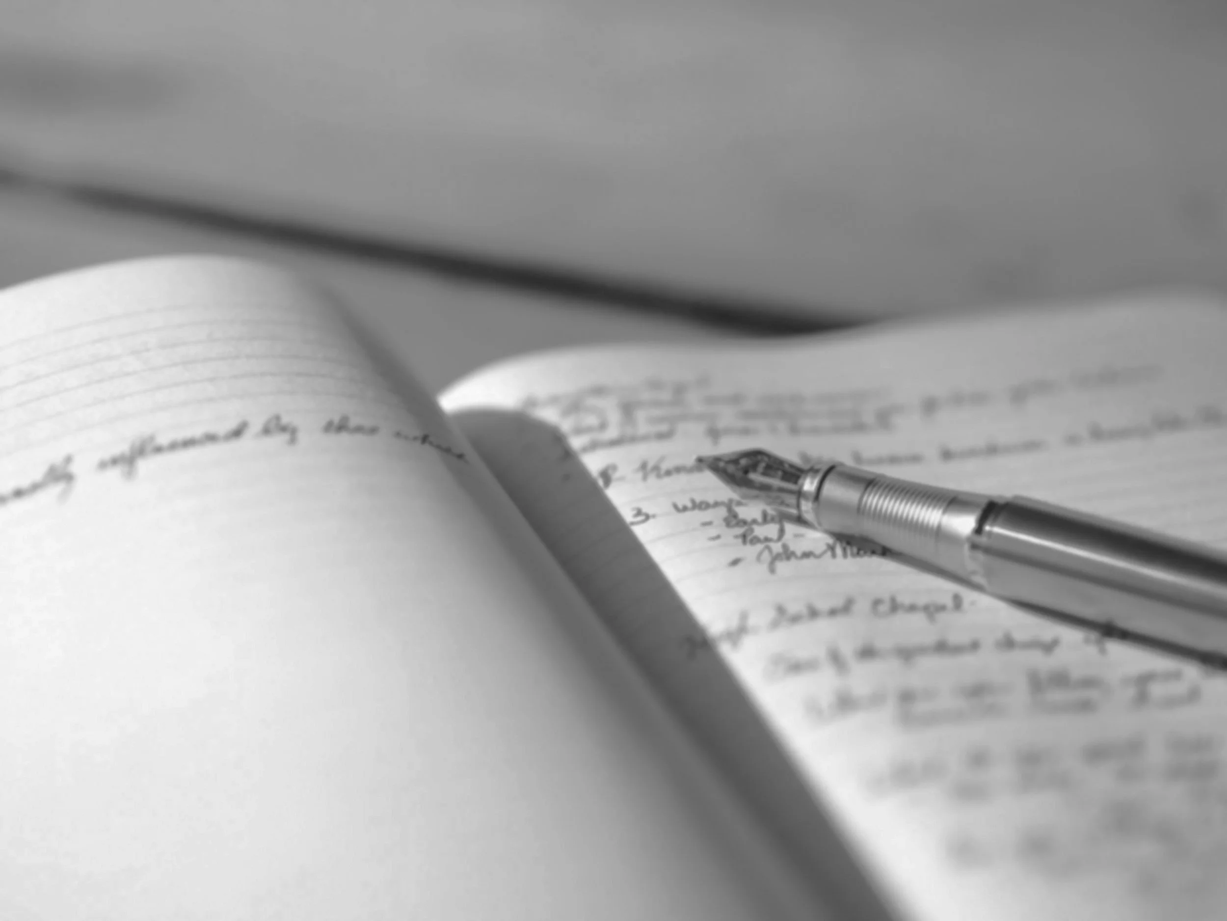 Open notebook with handwritten notes and a fountain pen resting on it.