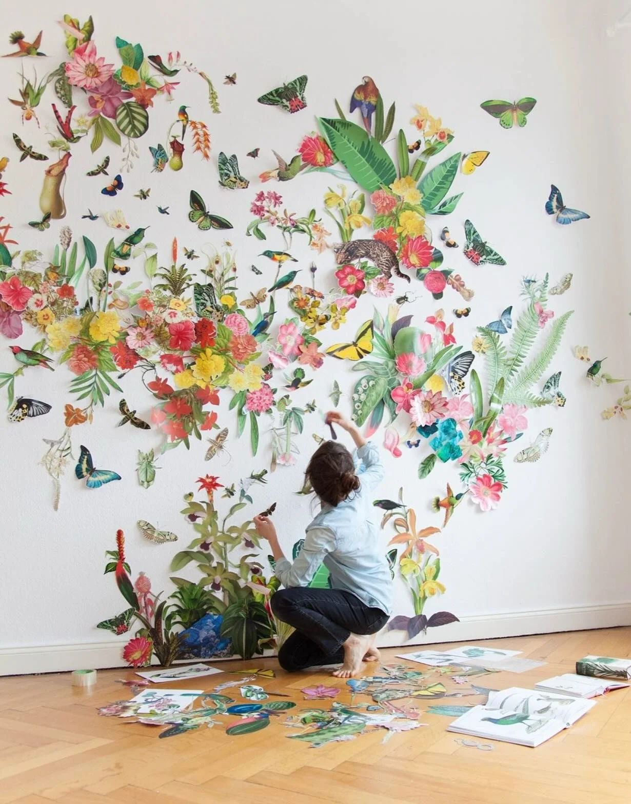 Clare Celeste is a Berlin-based artist known for immersive paper installations that honor the beauty and fragility of the natural world. Using thousands of hand-cut botanical and zoological images sourced from vintage books, she creates layered ecosy