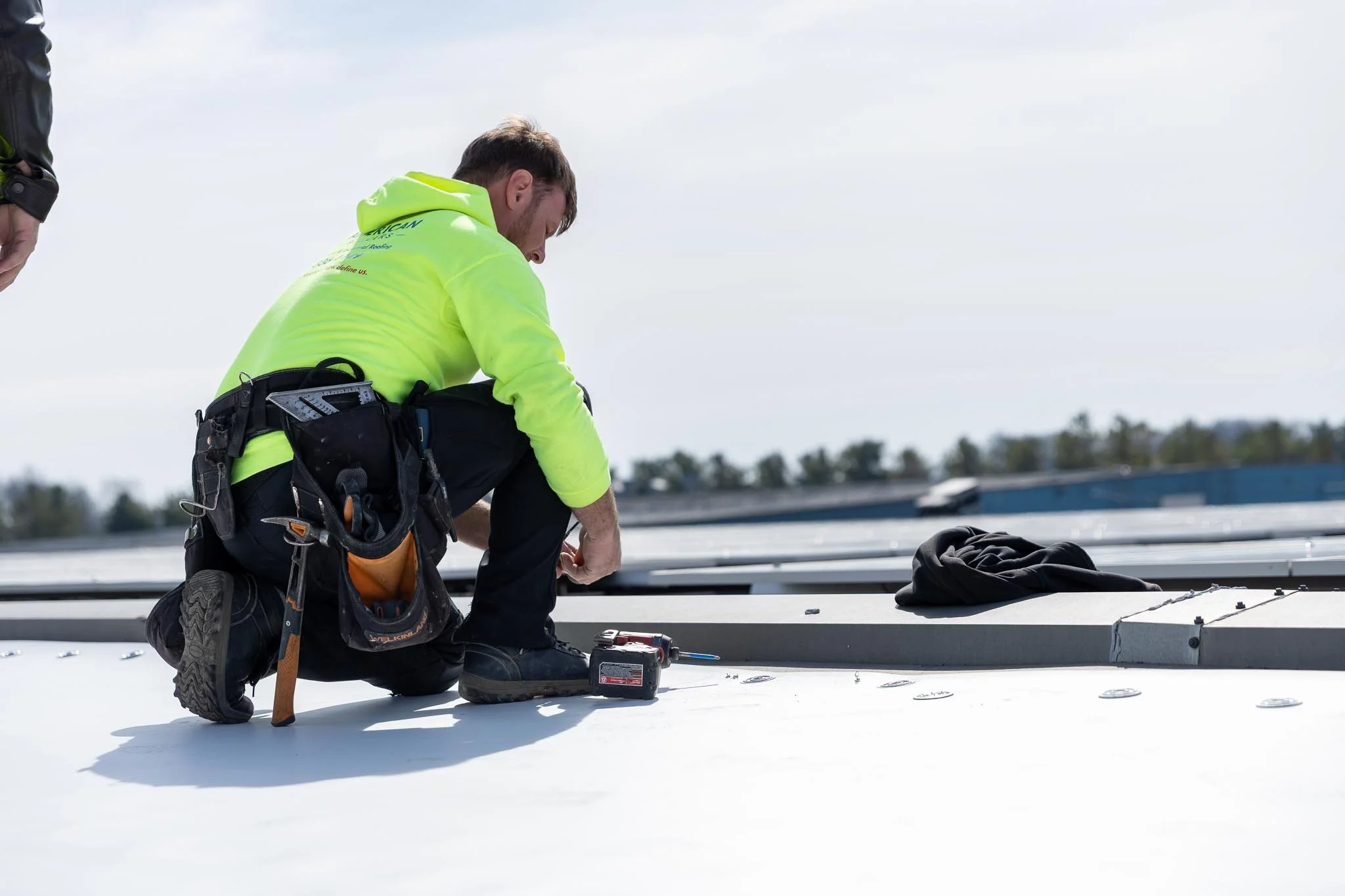 Commercial roofing contractor installing reflective roof system on flat commercial roof in Indiana