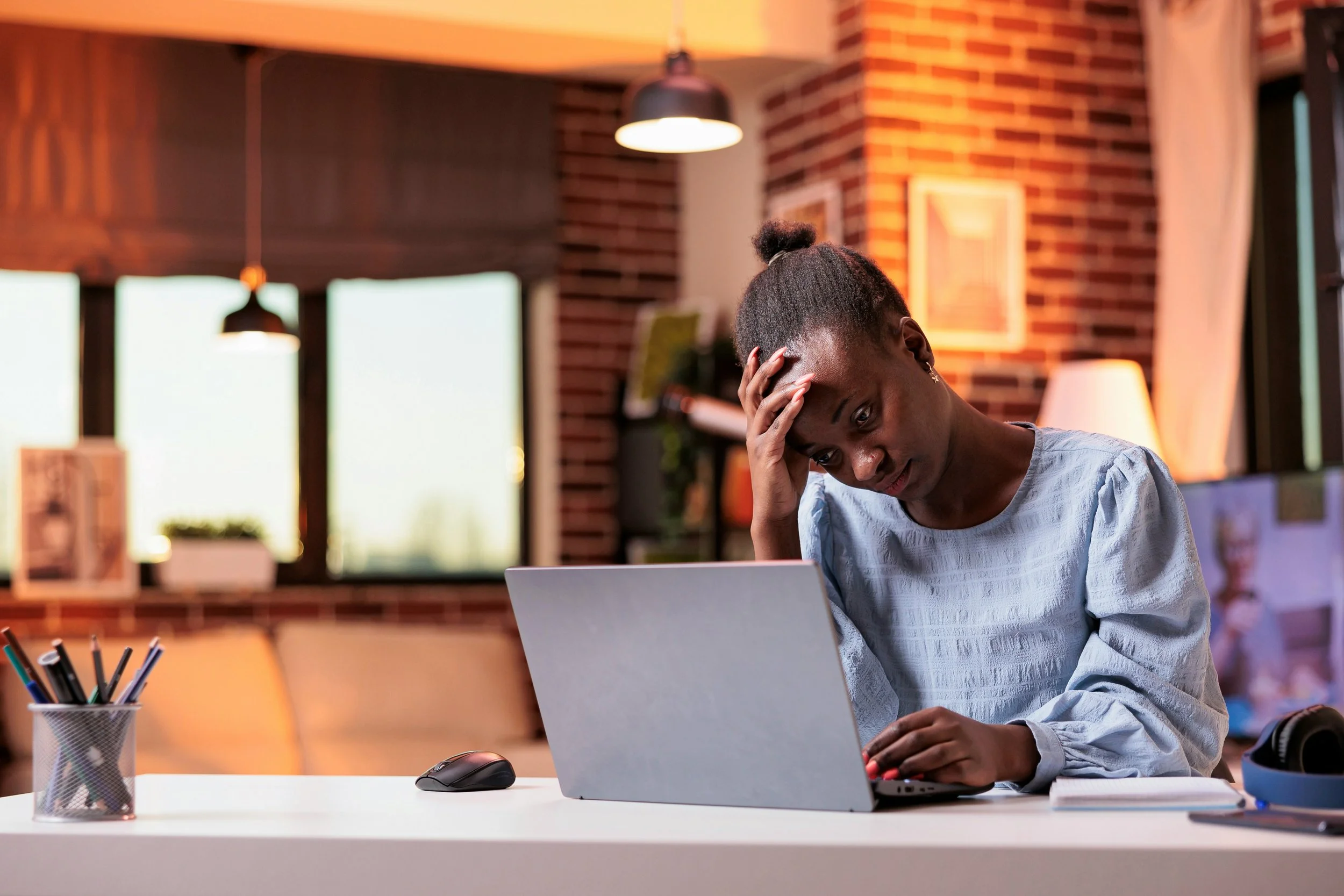 Young professional at a desk in a New York City apartment on a Sunday evening, representing work stress and burnout