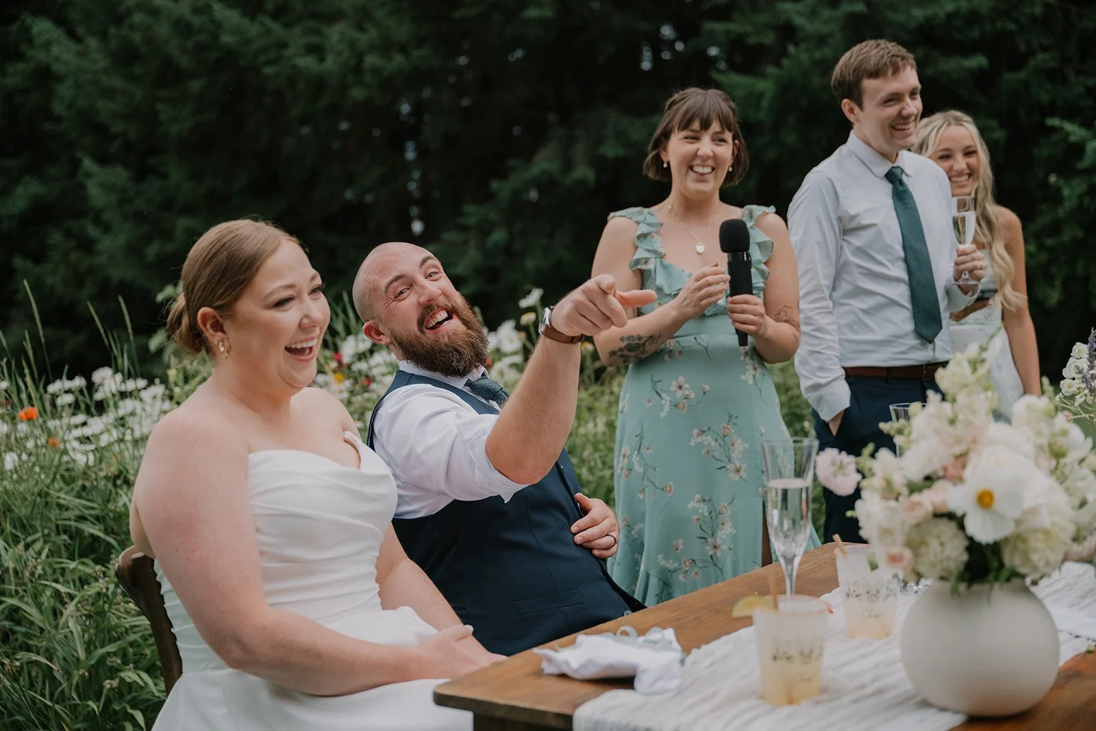 Bride and groom enjoying wedding reception with guests at intimate Pacific Northwest outdoor wedding.
